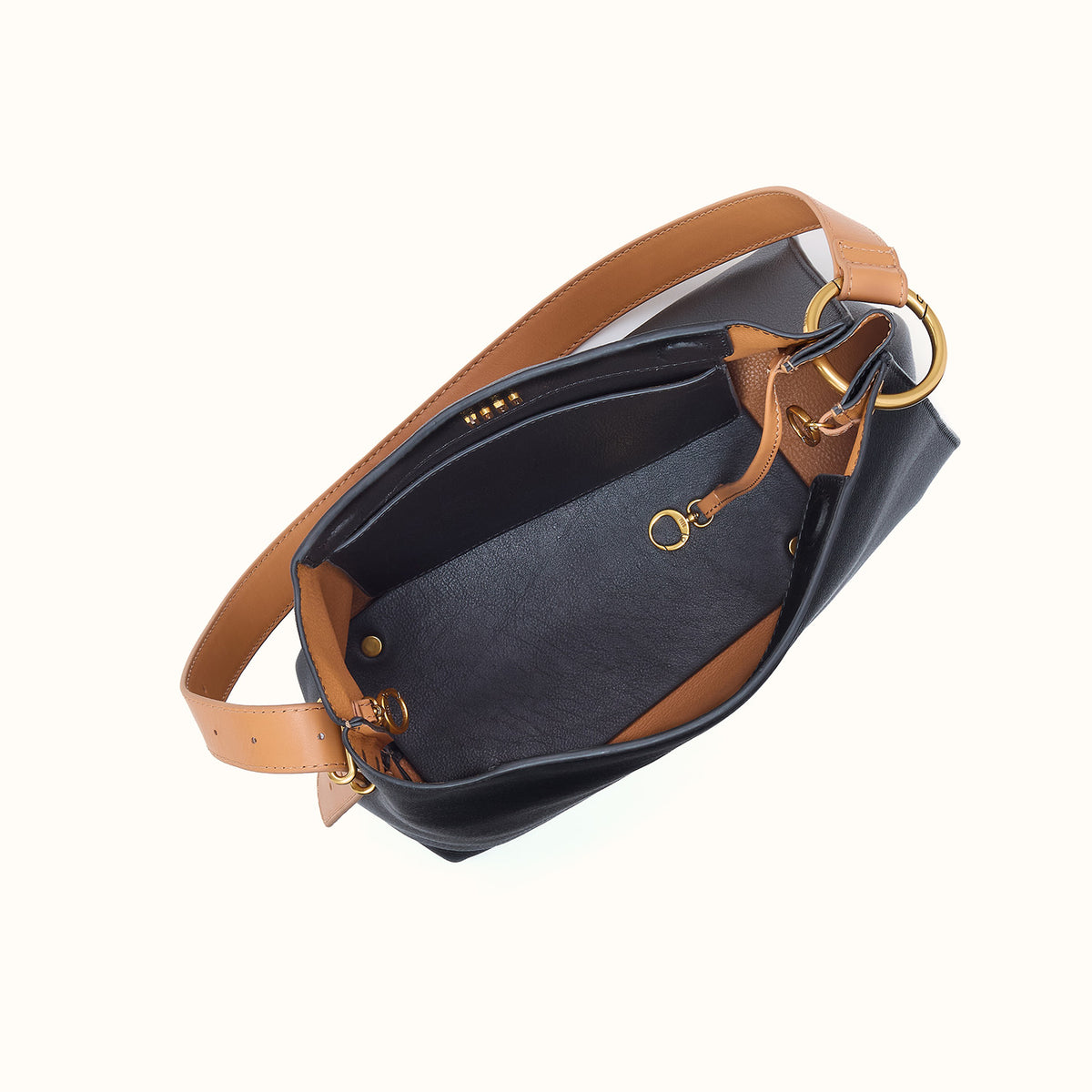 Black handbag with brown leather straps on a light gray background