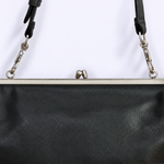 Close-up of a black pebbled leather handbag with a silver metal frame and strap clasp hardware against a plain white background.